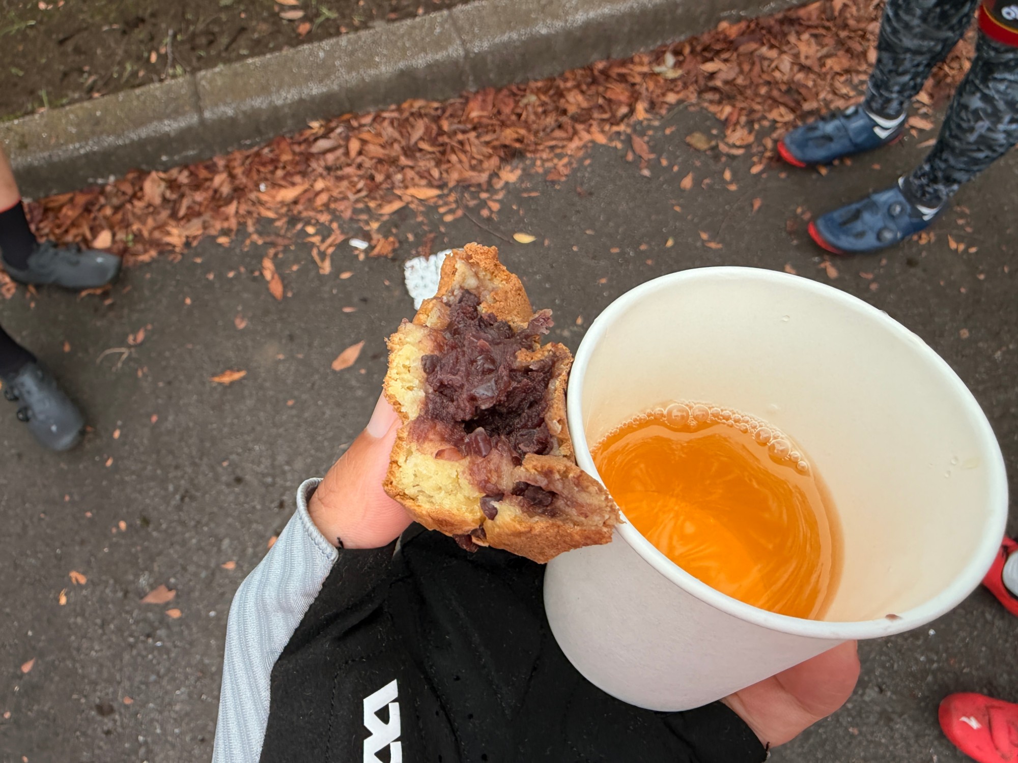 粒あんがたっぷり入った焼き菓子と、紙コップに入ったオレンジ色の飲み物