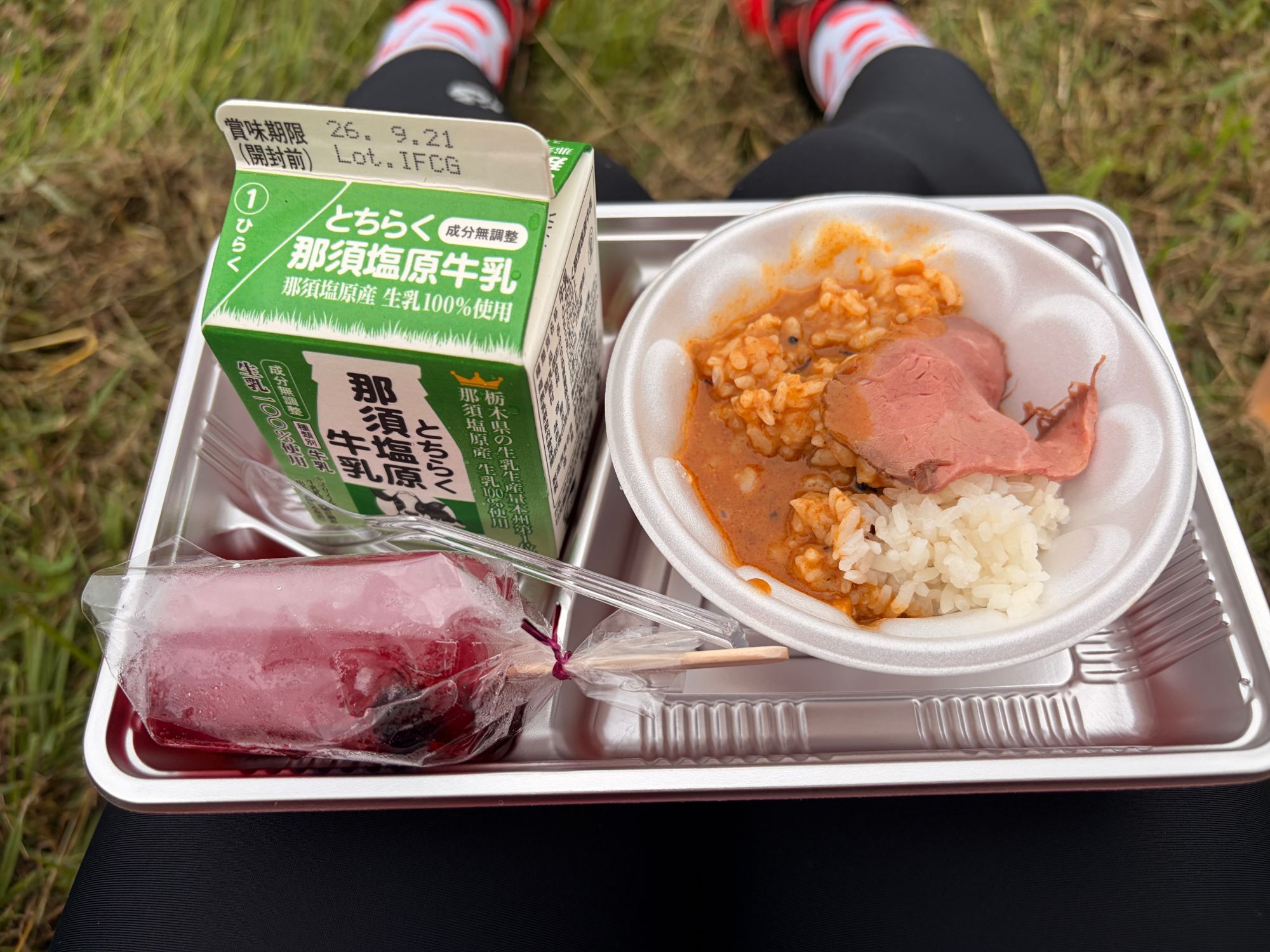 トレーに載った那須塩原牛乳の紙パック、ローストビーフの載ったカレーライス、袋入りの冷たいデザート